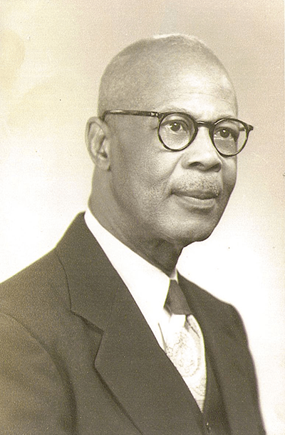 Farmer Sr. in spectacles and dark suit